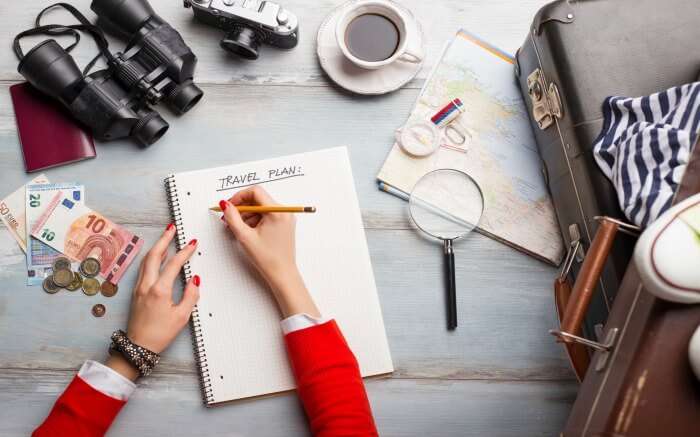 Top view of a woman writing travel plans