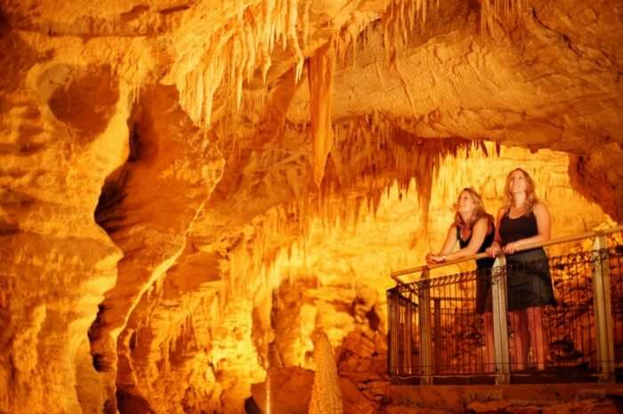 Visitors marveling the well lit interiors of Ruakuri Caves in Waitomo