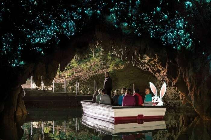 Travelers taking a tour of the Waitomo Glowworm Caves in New Zealand