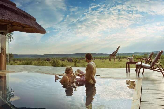 Couple spending romantic moments in a pool during safari honeymoon in South Africa