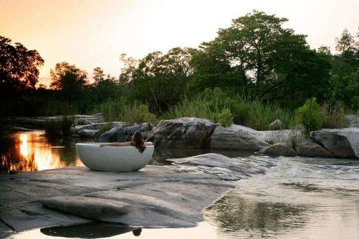 A honeymooner bathing in a tub in a jungle lodge during a safari honeymoon in South Africa