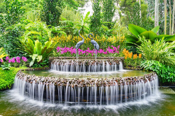 a fountain with pink flowers on the top