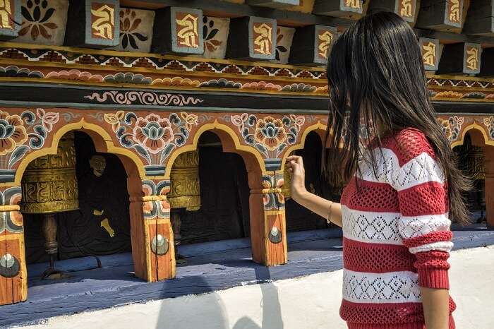 solo female traveler exploring a Buddhist temple in Bhutan