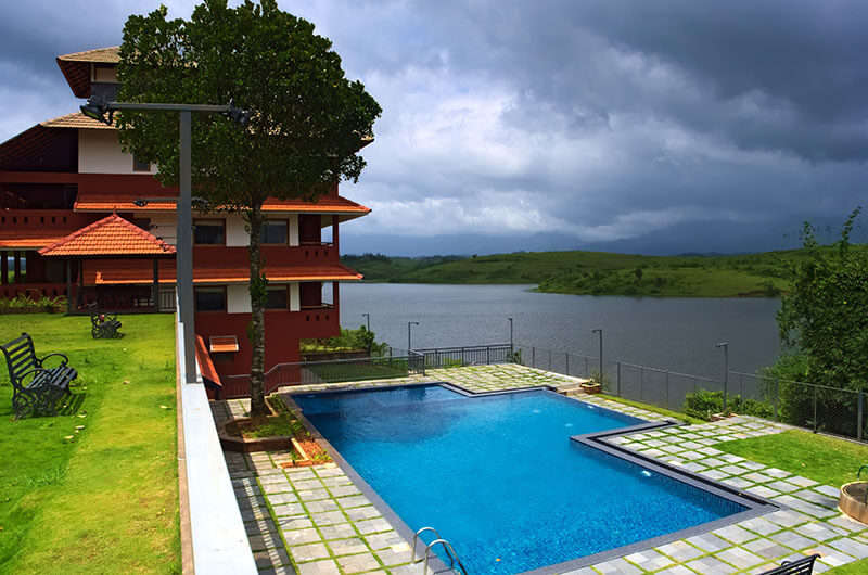 Open air pool area of Vistara Resorts by the lake in Wayanad
