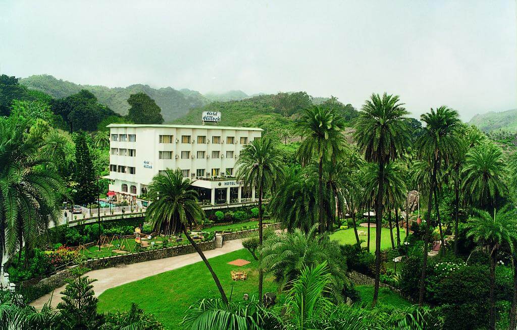 Hotel Hillock white colour building with palm trees in front 