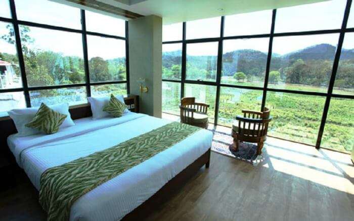 glass wall hotel room with mountain views at Hotel Tiger Roare 