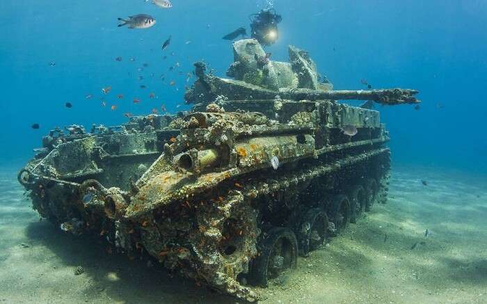 Sea divers passing a tank that got sunk in the Gulf of Aqaba in Jordan