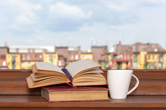 Books and a coffee cup on a windowsill