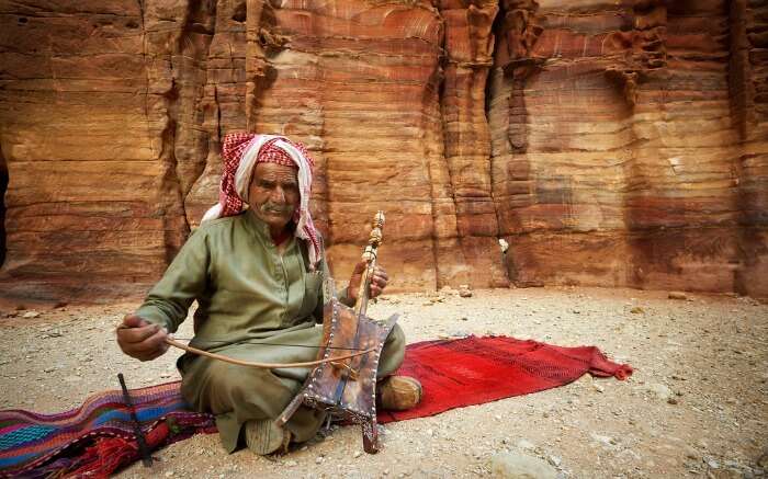 An old bedouin man playing traditional instrument