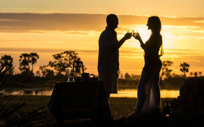 Couple raising a toast during their honeymoon in Botswana 