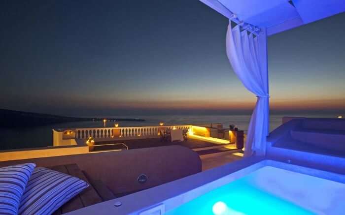 Luxury Jacuzzi pool at terrace of Oia Mansion at night 