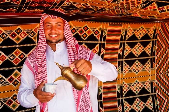 A friendly and welcoming Jordanian happily serving tea to the tourists