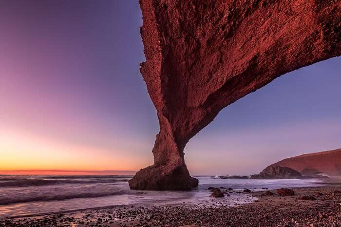 Sunset at red arches of Legzira beach at Sidi Ifni in Morocco