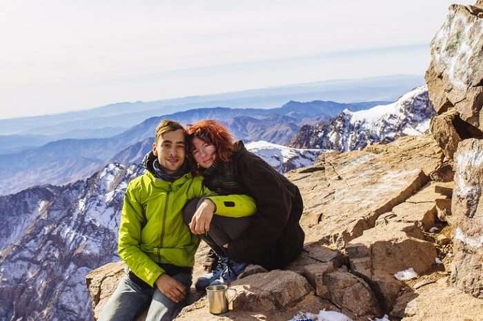 A couple sitting in the mountains of Toubkal in High Atlas mountain area durng their honeymoon in Morocco