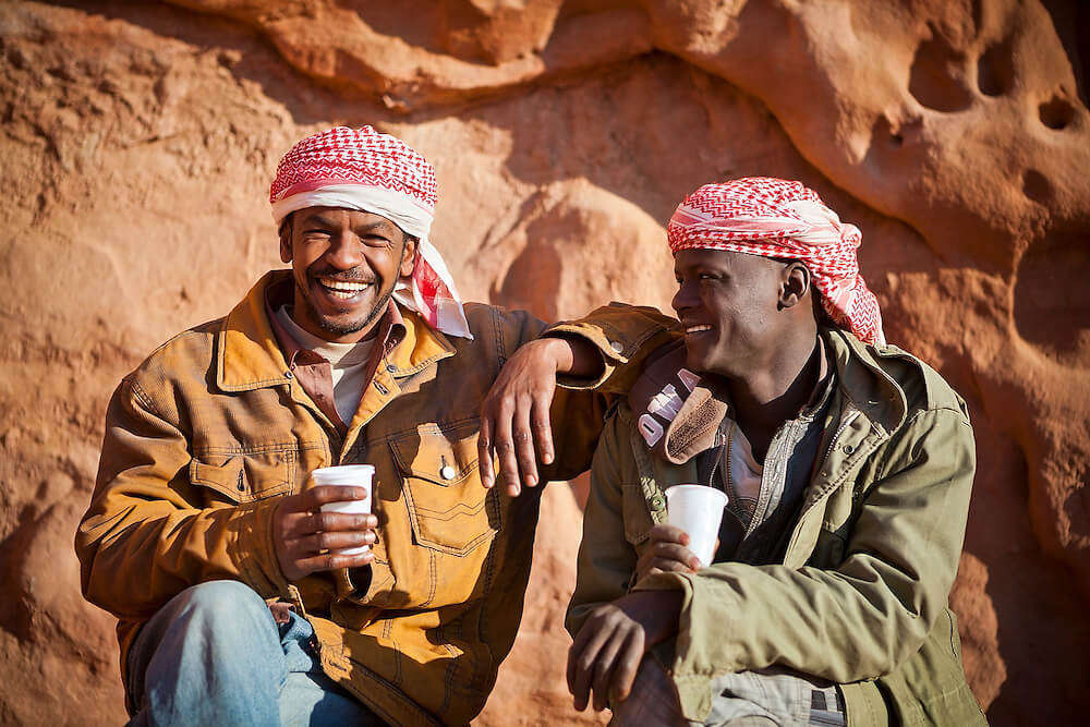 two Bedouin guys drinking tea laughing 