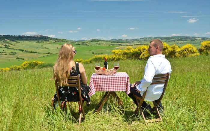 A couple sitting amid fields of Tuscany 