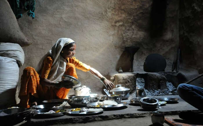 A local village woman cooking traditional food for tourists in Purushwadi 