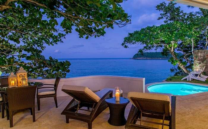 A swimming pool and comfortable sundecks in balcony of a resort in Jamaica