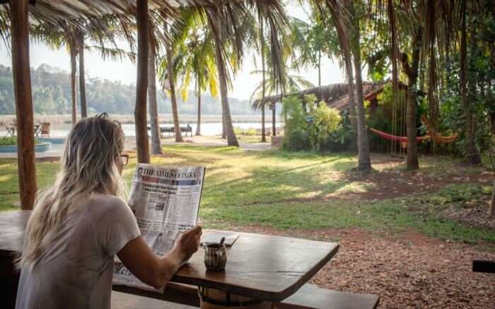 A traveler reading a newspaper at Olaulim Backyards homestay in Goa