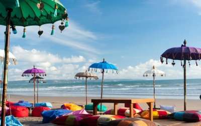 Colourful bean bags with a wooden table on Kuta beach 