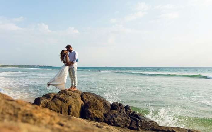 Couple kissing on a cliff by the sea shore in Sri Lanka 