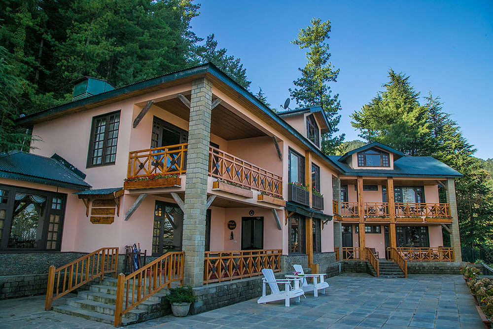 A villa style hotel building surrounded by trees