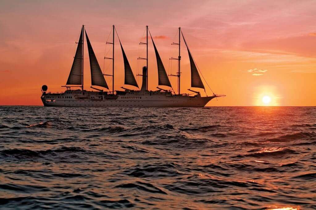 a cruise sailing on water during sunset