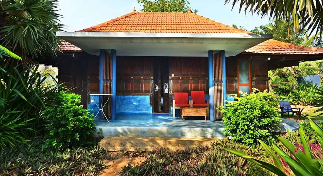 A south Indian style cottage surrounded by palms