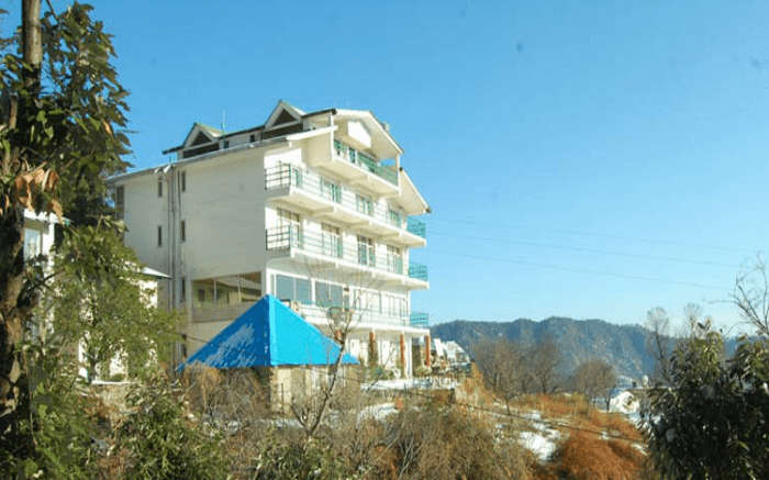 The beautiful view of Fernhill Resort Chail as captured from a nearby bush