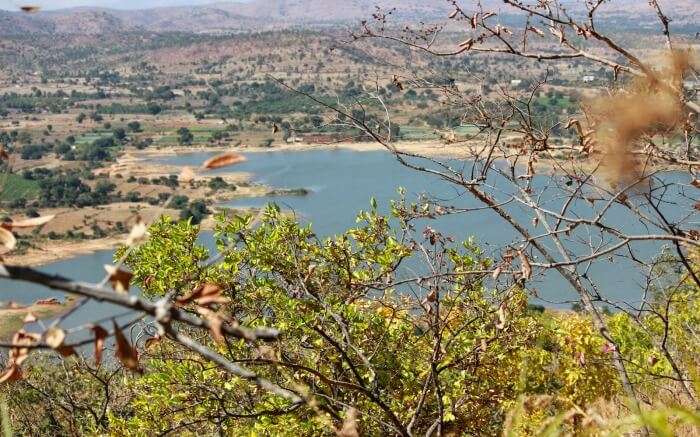 a cliff overlooking a lake and hills in Makalidurga