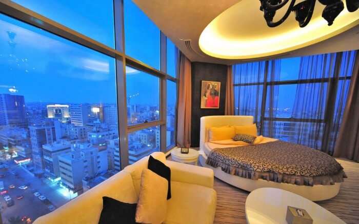 a hotel room with a bed and city view