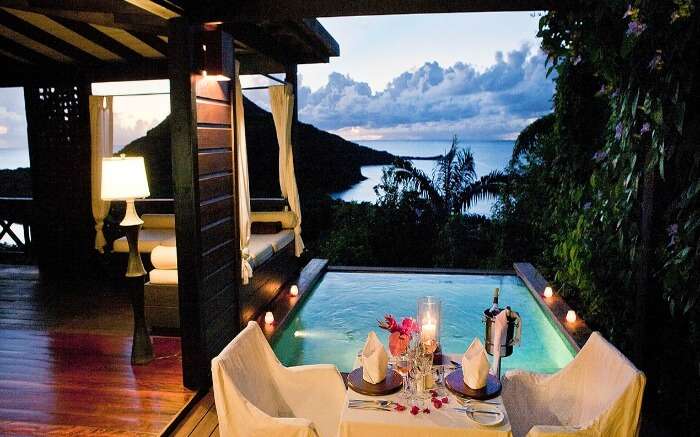 a romantic dining setting beside a pool overlooking the sea 