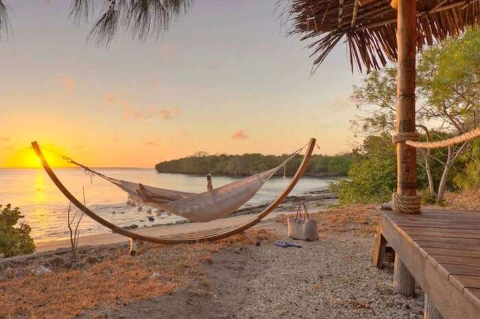 A woman relaxing by the beach in a hammock on a Mozambique Island