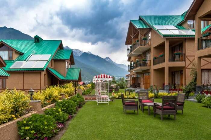 A view of cottages of Anantmaya Resort with mountains in the backdrop