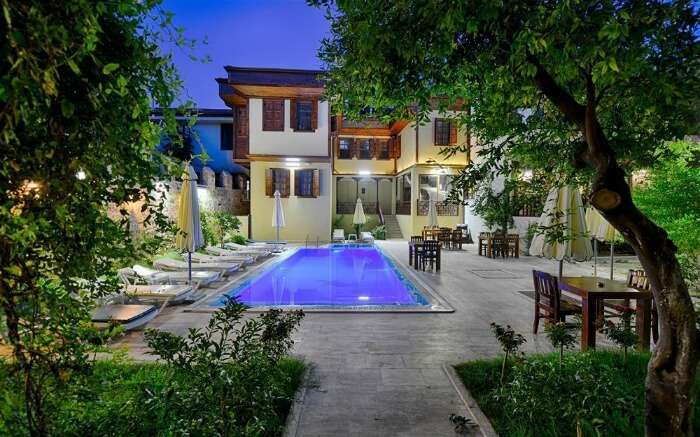 an outdoor pool surrounded with trees and plants