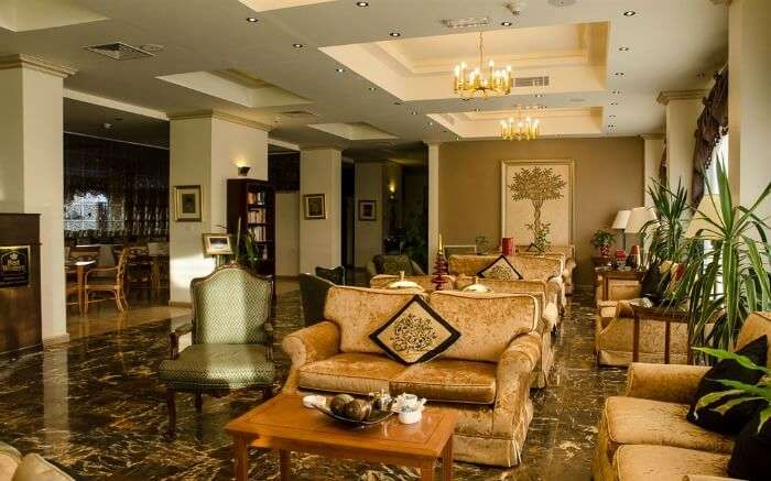 beautiful chandeliers and luxurious couch in a lobby of a hotel