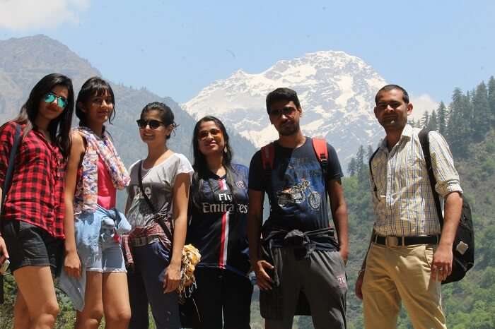 Young travelers pose in Kasol with the beautiful hills in the background