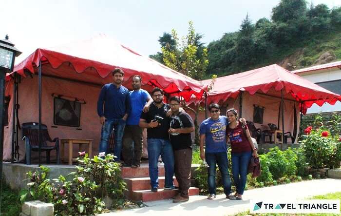 A bunch of travelers pose for a photgraph outside their tents in Chakrata