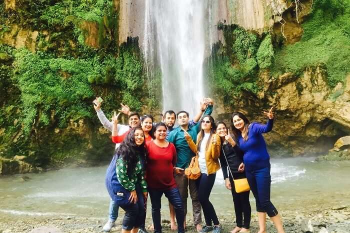 A group of travelers enjoying at the Tiger Falls in Chakrata on their weekend trip from Delhi
