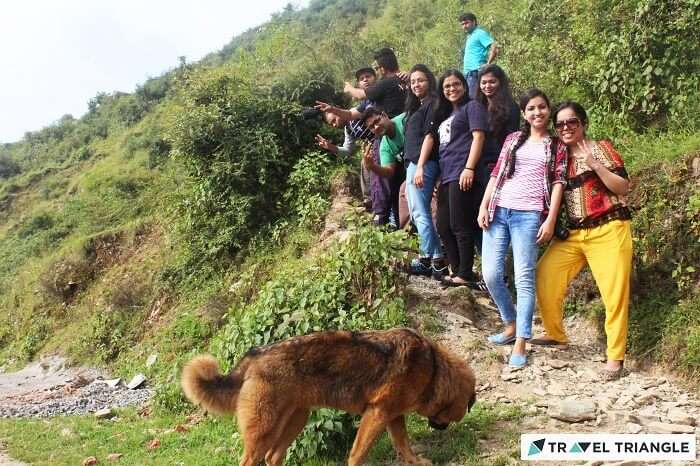 Travelers pose for a photgraph before continuing on their hike on a narrow trail on their weekend trip from Delhi to Chakrata