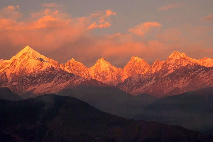 A sunset view of the reddish-orange color over the snow capped Himalayas as seen from Kausani