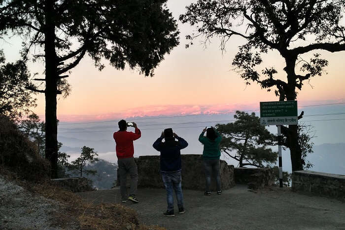 Travelers clicking pictures of the hills at sunset in Lansdowne