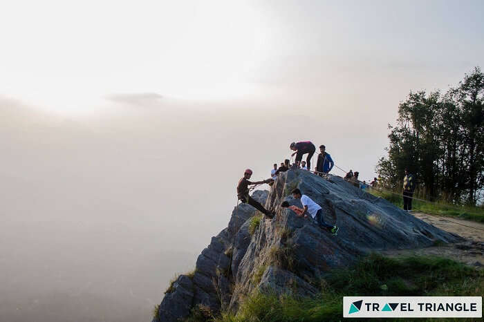 A bunch of travelers trying rock climbing on one of the weekend trips from Delhi to Mukteshwar