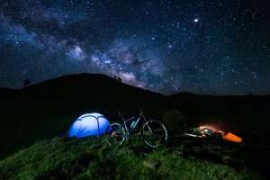 A night shot of a tent set up near Prashar Lake under the starry sky