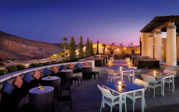 romantic sitting area of terrace overlooking mountains at night