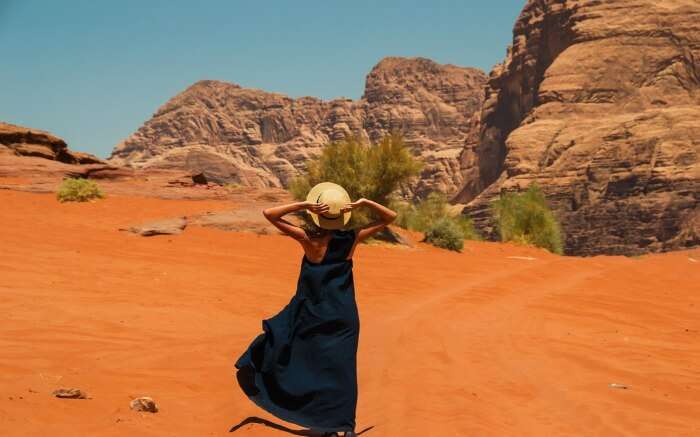 women wearing long western dress with hat in the deserts of Wadi Rum 