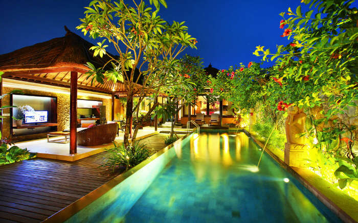 A beautiful outdoor pool in a resort at night 