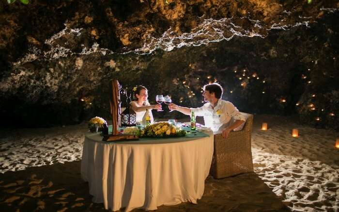 A couple having a romantic dinner in a romantic cave 