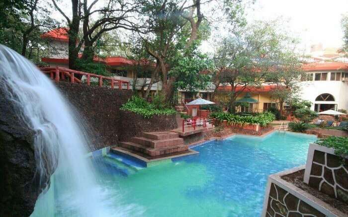 A fountain gushing into the pool of Horseland Hotel & Mountain Spa in Matheran