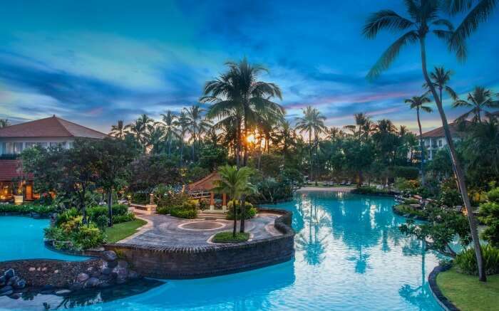 A gorgeous outdoor pool and palm trees in resoort premises 